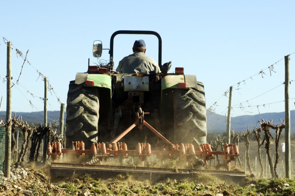 A man on a tractor plowing the field.